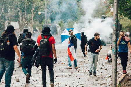 SANTIAGO, CHILE-NOVEMBER 8, 2019 - Protesters protect themselves from riot police during the...