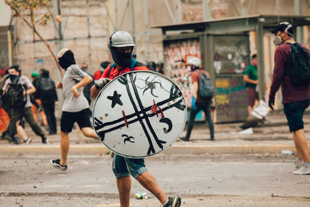 SANTIAGO, CHILE-NOVEMBER 8, 2019 - Protester protect themselves from riot police with improvised shields during the protests against the government of Pinera, for the social crisis in the countryのeditorial素材
