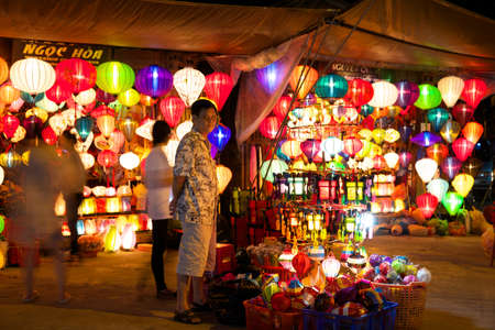 Vietnamese man selling colorful lanterns at market street of Hoi An, Vietnamのeditorial素材