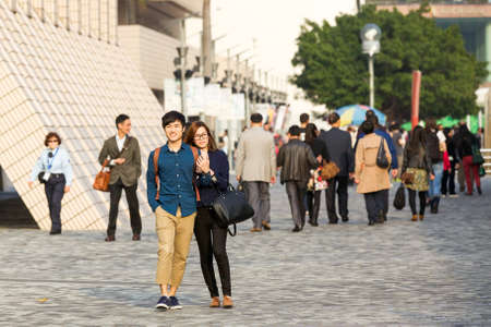 HONG KONG  - FEBRUARY 26: Young couple walking  at the crowded street holding each other on February 26, 2014 in Hong Kong.のeditorial素材