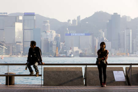 HONG KONG  - FEBRUARY 26: Young woman and man are resting at the Tsim Sha Tsui Promenade on February...