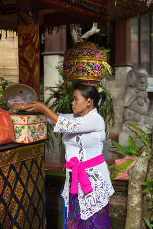 UBUD, INDONESIA - MARCH 2: Woman with basket on the head during the celebration before Nyepi (Balinese Day of Silence) on March 2, 2016 in Ubud, Indonesia.のeditorial素材