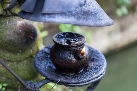 Burning oil lamp in Pura Saraswati Temple. Ubud, Bali, Indonesia.