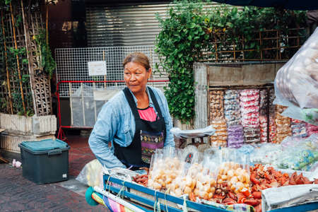 BANGKOK, THAILAND - APRIL 24: Woman selling fruits on the street of Bangkok Chinatown on April 24, 2016 in Bangkok, Thailand.のeditorial素材