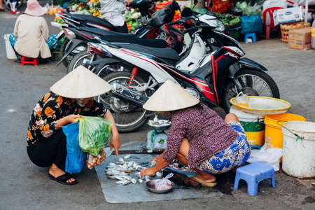 NHA TRANG, VIETNAM - JANUARY 20: Vietnamese woman in traditional conical hat is selling fish at the wet market on January 20, 2016 in Nha Trang, Vietnam.のeditorial素材