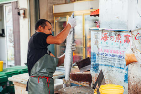 GEORGE TOWN, MALAYSIA - MARCH 23: Man prepare the fish for sale at the wet market on March 23, 2016 in George Town, Malaysia.のeditorial素材