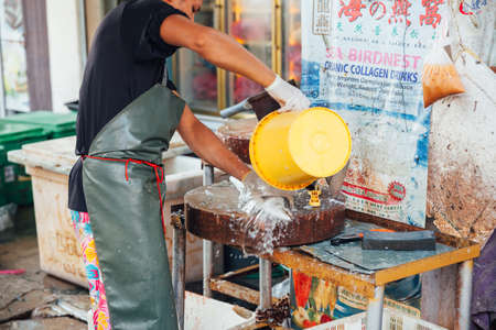 GEORGE TOWN, MALAYSIA - MARCH 23: Man prepare the fish for sale at the wet market on March 23, 2016 in George Town, Malaysia.のeditorial素材