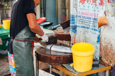 GEORGE TOWN, MALAYSIA - MARCH 23: Man prepare the fish for sale at the wet market on March 23, 2016...