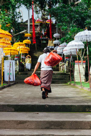UBUD, INDONESIA - MARCH 2: Man in traditional balinese clothes walks up the stairs during the celebration before Nyepi (Balinese Day of Silence) on March 2, 2016 in Ubud, Indonesia.のeditorial素材
