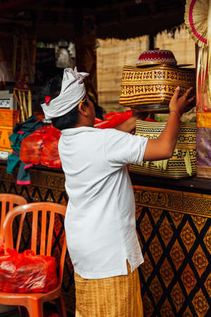 UBUD, INDONESIA - MARCH 2: Boy takes the offering box during the celebration before Nyepi (Balinese Day of Silence) on March 2, 2016 in Ubud, Indonesia.のeditorial素材