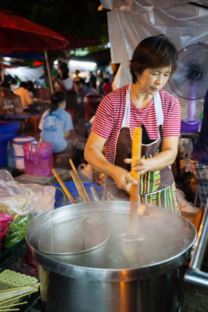 CHIANG MAI, THAILAND - AUGUST 27: Woman cooks at the Sunday Market (Walking Street) on August 27, 2016 in Chiang Mai, Thailand.のeditorial素材
