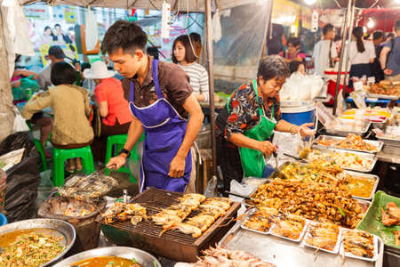 CHIANG MAI, THAILAND - AUGUST 27: Man cooks prawns on the grill at the Sunday Market (Walking Street) on August 27, 2016 in Chiang Mai, Thailand.のeditorial素材