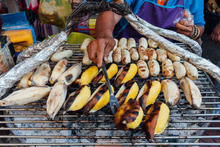 BANGKOK, THAILAND - APRIL 24: Woman selling grilled banana in Bangkok Chinatown on April 24, 2016 in Bangkok, Thailand.のeditorial素材