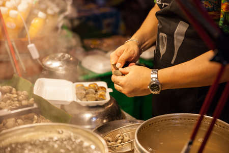 CHIANG MAI, THAILAND - AUGUST 27: Man prepare clams for sale at the Sunday Market (Walking Street) on August 27, 2016 in Chiang Mai, Thailand.のeditorial素材