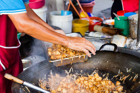 GEORGE TOWN, MALAYSIA - MARCH 23: Man cooks food at Kimberly Street Food Night Market on March 23, 2016 in George Town, Malaysia.の写真素材