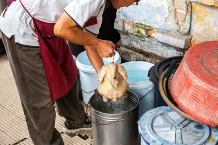 IPOH, MALAYSIA - DECEMBER 11: Man cooks chicken on the street of Ipoh on December 11, 2018 in Ipoh, Malaysia.のeditorial素材