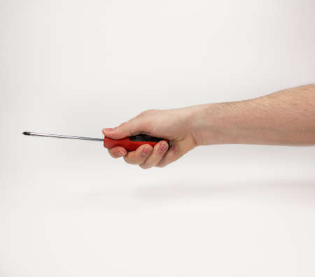 Hand holding screwdriver on whiteの写真素材