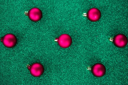 Red Christmas decorations pattern on green background.の写真素材