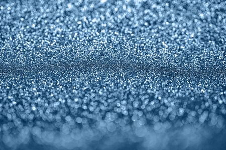 Abstract blue defocused bokeh glitter sparkle confetti burst background. Festive concept.