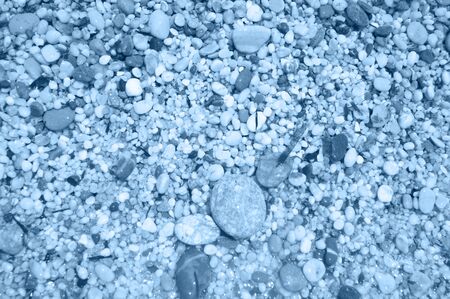 Macro close up of coarse rice-sized blue wet shiny sand grains and gravel texture, top view. Color of the year.の写真素材
