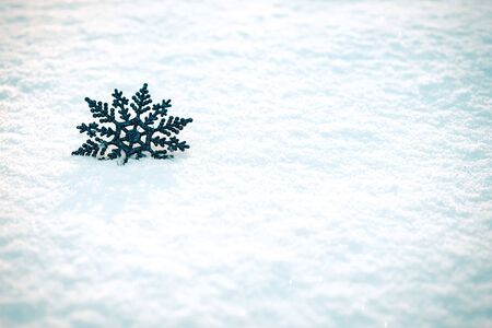 Silver blue Christmas Decoration snowflake on the snow. Natural light. Holiday and New Year concept.