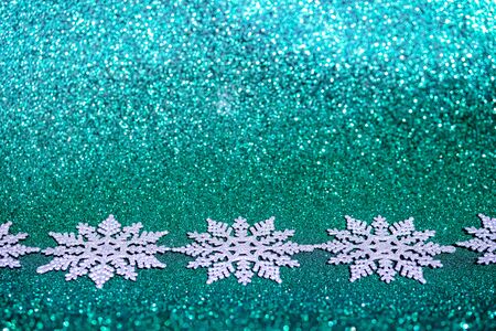 Defocused silver Christmas decorations on biscay turquoise green background.の写真素材