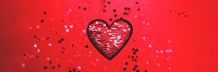 Red and silver heart of sequins on blue background. 14 February, Valentine's day concept. Perfect...
