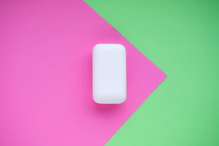 Bar of white soap on green and pink magentaの写真素材