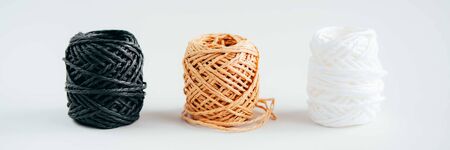 Three balls of yarn, white, black and beige, on gray background. Sewing, stitchcraft, hobby concept. Web banner.の写真素材
