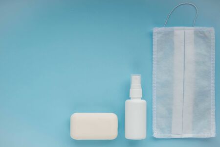 Coronavirus prevention set. White medical mask and hand sanitizer gel and a bar of soap for hand...