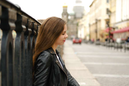Young woman with long hair walking along the street of a big city. Saint Petersburg, Russia.の写真素材