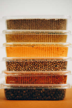 various colorful spices and herbs packed in small transparent plastic bags stacked in a pileの写真素材