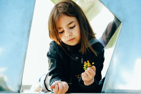 Little girl in stylish autumn black outfit in an urban setting looking tothe sky.の写真素材