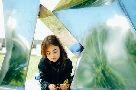 Little girl in stylish autumn black outfit in an urban setting looking tothe sky.の写真素材