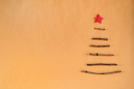 Creative sustainable Christmas tree made of wooden sticks, dry berries and pine cones. Minimal DIY design on craft paper background with copy space. No plastic natural design.の写真素材