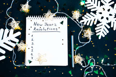 New Years goals. the list of resolutions in a notepad on dark green background. Resolution Aspirations Motivation Conceptの写真素材