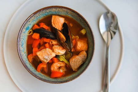 Bowl of fresh seafood soup with salmon, mussels, vegetables and shrimps.の写真素材