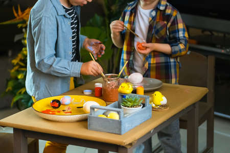 Little boys painting wooden eggs for Easter decoration. Candid image of kids crafting.の写真素材