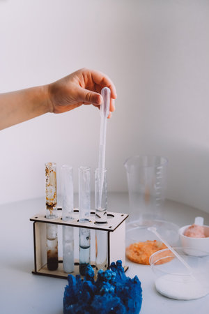 Hands of a child holding test tube making chemical educational experimentsat home