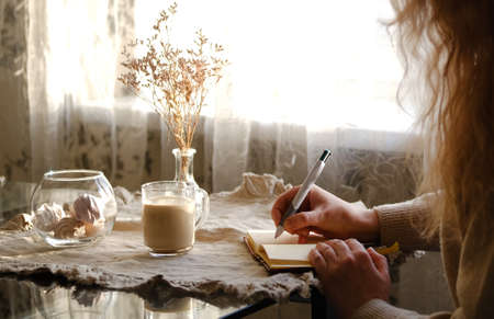 Cropped image of woman drinking coffee and reading a bookの写真素材