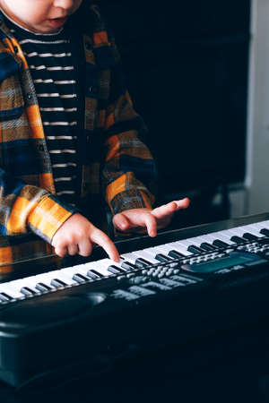Close up of childs hands plying electric pianoの写真素材