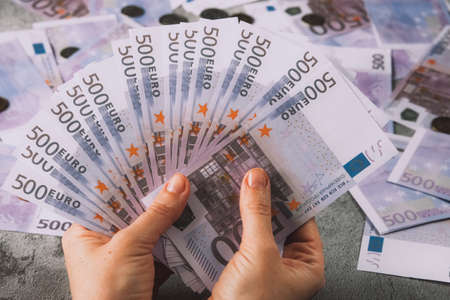 Several five hundred euro banknotes in womans hand. Money concept.