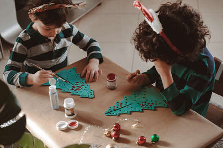 Two little kids making Christmas decorations painting tree.の写真素材