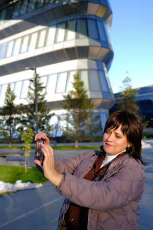 Woman in her thirthies using her phone walking