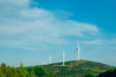 Wind farm with several wind turbines on the hill.