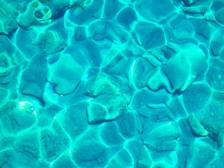 Turquoise surface of transparent sea water with sun glintsの写真素材