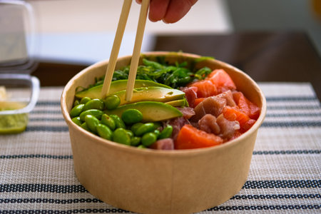 Frash raw appetizing poke bowl with salmon, avocado, rice.
