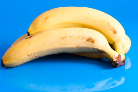 small bunch of ripe bananas isolated on light blue backgroundの写真素材