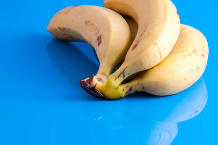 small bunch of ripe bananas isolated on light blue backgroundの写真素材
