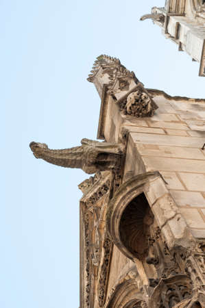 View of a typical French architecture with gargoyles sprouting of a church facadeの写真素材